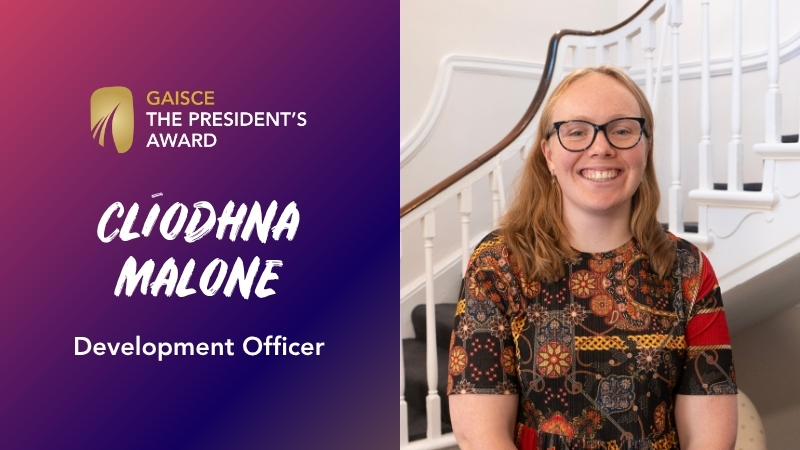 gaisce logo (gold medal with 3 arches of increasing size at bottom), clíodhna malone, development officer, with an image of clíodhna. she has blonde hair, glasses, smiling bright and is wearing a shirt with splashes of orange, red, black.