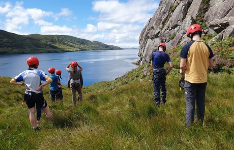 image of people standing at a cliff looking out on the sea