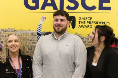 Three people smiling at the Oberstown Gaisce Award ceremony at Ratra House.